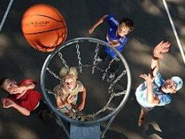 Kinder werfen Basketball in Korb